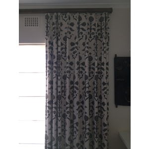 Patterned pinch pleated curtains on rod